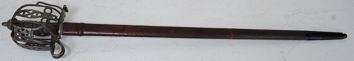 A late Victorian officer’s sword of the Black Watch, claymore blade etched with regimental title and VR cipher, regulation basket hilt, fish skin covered grip, in its leather covered field service scabbard, blade 82cm. C